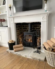 a fireplace with logs and a television above it