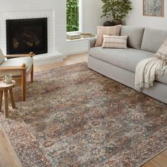 a living room filled with furniture and a fire place in the middle of the room