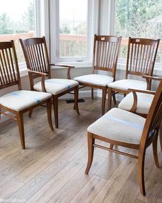 six wooden chairs in front of a large window