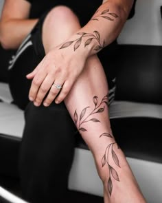 a woman with tattoos on her legs sitting in front of a black and white chair