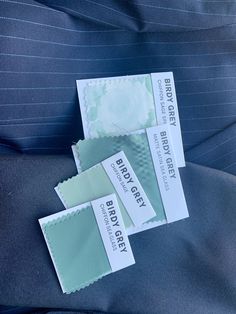 three business cards sitting on top of a blue suit