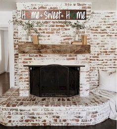 a living room with a brick fireplace and white couch in front of the fire place