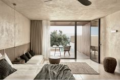 a bedroom with two beds and a ceiling fan in front of a sliding glass door