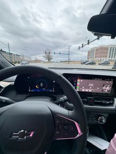 the interior of a car with steering wheel, dashboard and display screen showing information about cars