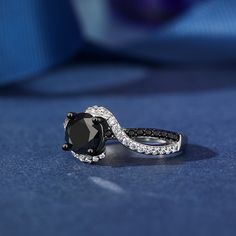 This captivating ring features a mesmerizing swirl design, combining the contrasting beauty of black and white stones. Two ribbons, one lined with black stones, the other with shimmering white stones, twist and swirl together to create the ring's shank. Its unique and contemporary style is sure to turn heads and add a touch of drama to any outfit.Carat Weight: 2.3 ctStone Size: 7 mmStone Type: Jeulia® StoneNumber of Stones: 1 Stone Color: Fancy BlackStone Shape: RoundCarat Weight: 0.798 ctStone Love Black And White, Black Stones, White Stones, Love Black, Swirl Design, White Stone, Black Stone, Quality Jewelry, Sterling Silver Ring