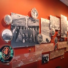 a wall with many different pictures and clocks on it's sides, along with other plaques