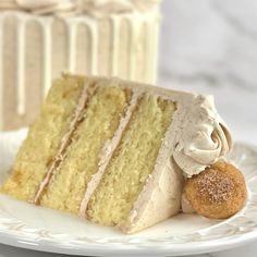 a slice of cake on a plate with two other cakes in the background