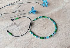 Adjustable shades of green and blue (Lagoon Color Mix) colored bracelet with a sliding closure! This one size bracelet is made with tiny 8/0 (3.1mm) Miyuki seed beads. It features shades of green and blue glass beads. The finish is macrame sliding knot on a black color high-quality Brazilian waxed cord. It may be tight at first but will become flexible over time. You can stack this bracelet with other bracelets or wear it alone. How to wear: Open the bracelet fully and slip over your hand, then pull the tail ends to your desired fit. ** This bracelet opens to about 10 inches to slip over your hand, then closes down to fit a wrist as small as 5.50 inches. ** Please message me if you are looking for a different size.  To maintain the quality of the stones and the bracelet keep them away from Handmaid Jewelry, Become Flexible, Bracelet Friendship, Bracelet Boho, Sliding Knot, Color Mix, Blue Lagoon, Boho Look, Colorful Bracelets