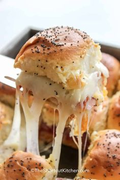 a close up of a hot dog bun being lifted with a spatula from a baking pan