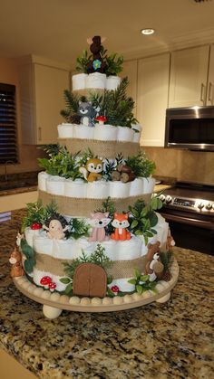 a three tiered cake decorated with animals and plants