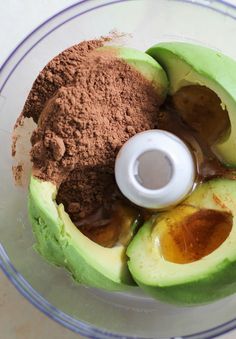 an avocado in a food processor with cocoa and other ingredients