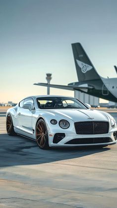 a white car parked in front of an airplane