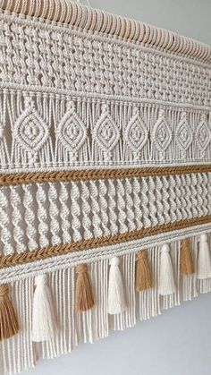 a white wall hanging with tassels on it