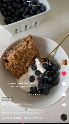 a bowl with cereal, yogurt and blueberries on it