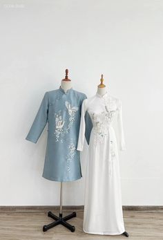 two dresses on mannequins in front of a white wall