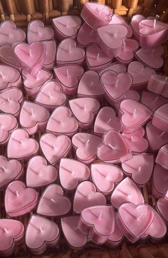 many pink candles are arranged in the shape of hearts