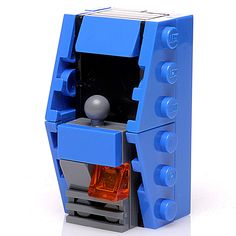 a blue and gray lego object with an orange light in it's center, on a white surface