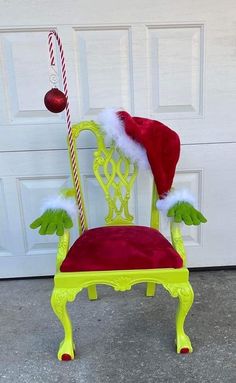 a green chair with red velvet seat and santa's hat on it, sitting in front of a garage door