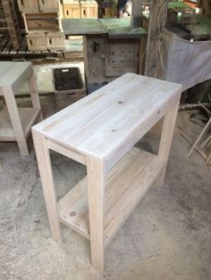 a wooden table sitting on top of a floor next to other woodworking tools and furniture