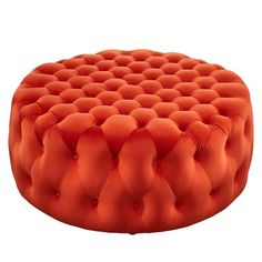 an orange round ottoman sitting on top of a white floor