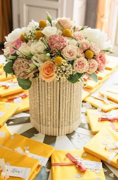 a basket filled with flowers sitting on top of a table covered in yellow napkins