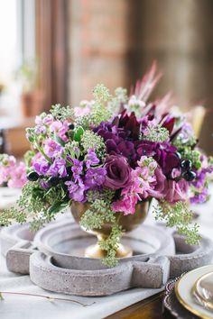 a vase filled with purple flowers sitting on top of a table