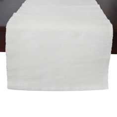 a white table runner on top of a wooden table