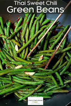 green beans are being cooked in a wok with chopsticks on the side