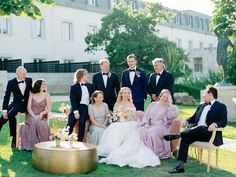 a group of people sitting on top of a lush green field next to each other