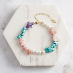 Step into a world of enchanting colors with our Dainty  Turquoise Pearl Bracelet , a delightful piece that brings together the serene hues of Turquoise, the ethereal glow of Shell Pearls, the soft radiance of Opal, and the regal touch of Amethyst.   Whether worn on a casual day out or as a unique statement piece for an evening event, this bracelet elevates your style with its playful yet refined aesthetic. Embrace the charm of this captivating piece and let it become a cherished part of your jewelry collection. DETAILS Plating: 14K Gold Materials: 925 Sterling Silver , Turquoise, Shell Pearl, Opal, Amethyst Stone: Turquoise(5-9mm/0.20"-0.35"), Shell Pearl(6mm/0.24"), Opal(5-8mm/0.2"-0.31"), Amethyst(5-8mm/0.2"-0.31") Measurements: Length: 6.50"(16.5cm) + Extender: 1.97"(5.0cm) Weight: 10.7 Gemstone Chips Bracelet, Silver Pearl Bracelet, Fruit Jewelry, Refined Aesthetic, Feather Necklaces, Amethyst Bracelet, Gold Bracelet Chain, Rose Gold Jewelry, Rose Gold Earrings