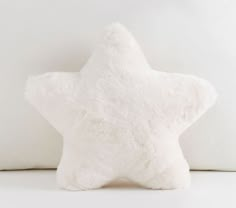 a white star pillow sitting on top of a bed