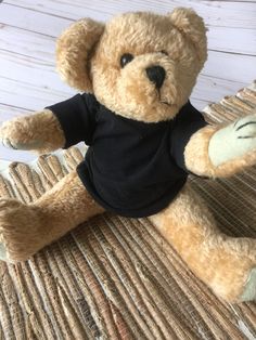 a brown teddy bear wearing a black shirt