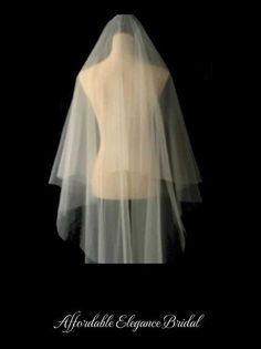 the back of a white veil on top of a mannequin's torso