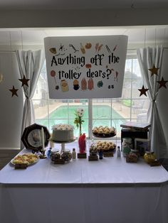 a table topped with cakes and desserts next to a sign that says, anything off the tolley deserts?