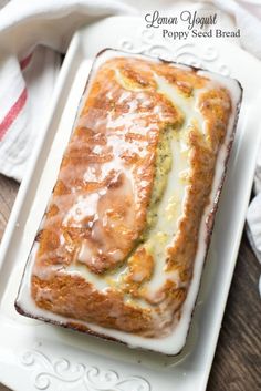 a white plate topped with a loaf of bread covered in icing and toppings