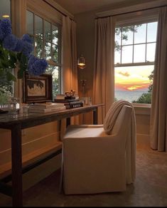 a room with a desk, chair and window overlooking the ocean