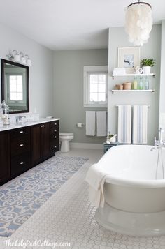 a large white bath tub sitting next to a sink in a bathroom under a mirror