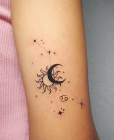 a woman's arm with a small sun and moon tattoo on the left side