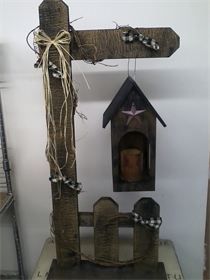 a birdhouse made out of wood with a star hanging from it's roof