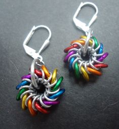 two pairs of multicolored earrings sitting on top of a table