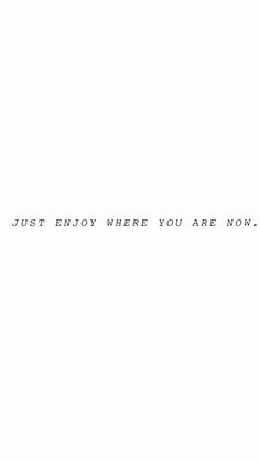 a white wall with the words just enjoy where you are now written in black ink