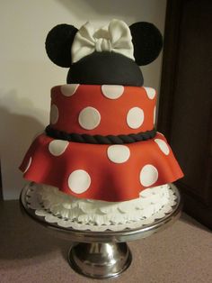 there is a cake that looks like minnie mouse on top of it, and has white polka dots