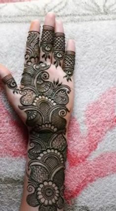 a woman's hand with henna tattoos on it