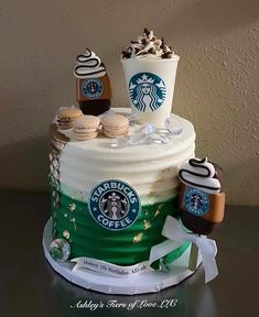 there is a cake decorated with starbucks drinks and cookies on the top, as well as two cups of coffee