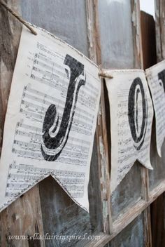 sheet music buntings are hung on an old door with the letter j in black and white