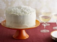 a white cake sitting on top of a table next to glasses of wine and plates