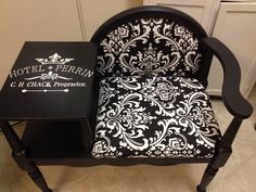 a black and white chair sitting next to a small table with a book on it