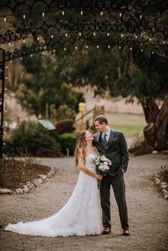 a bride and groom standing under an archway