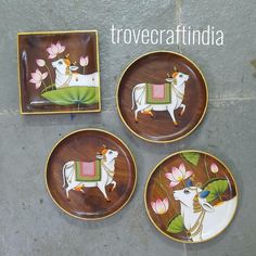 three decorative plates with animals on them sitting on the ground next to another plate that says trovecraftindia