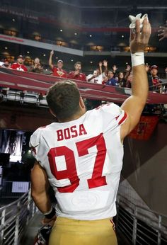 a football player is holding his hands up in the air